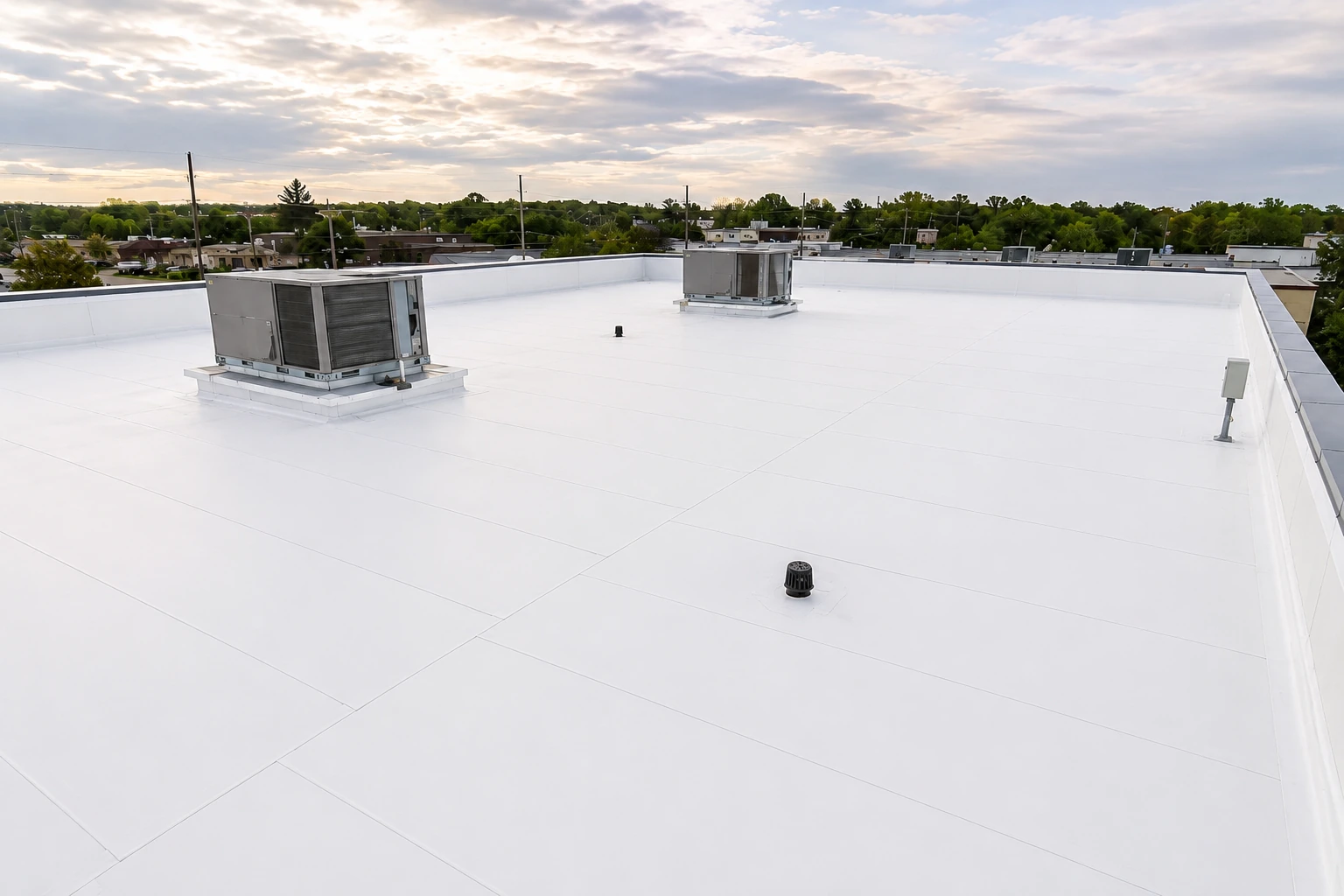 After: commercial flat roof with clean white membrane and rooftop HVAC equipment