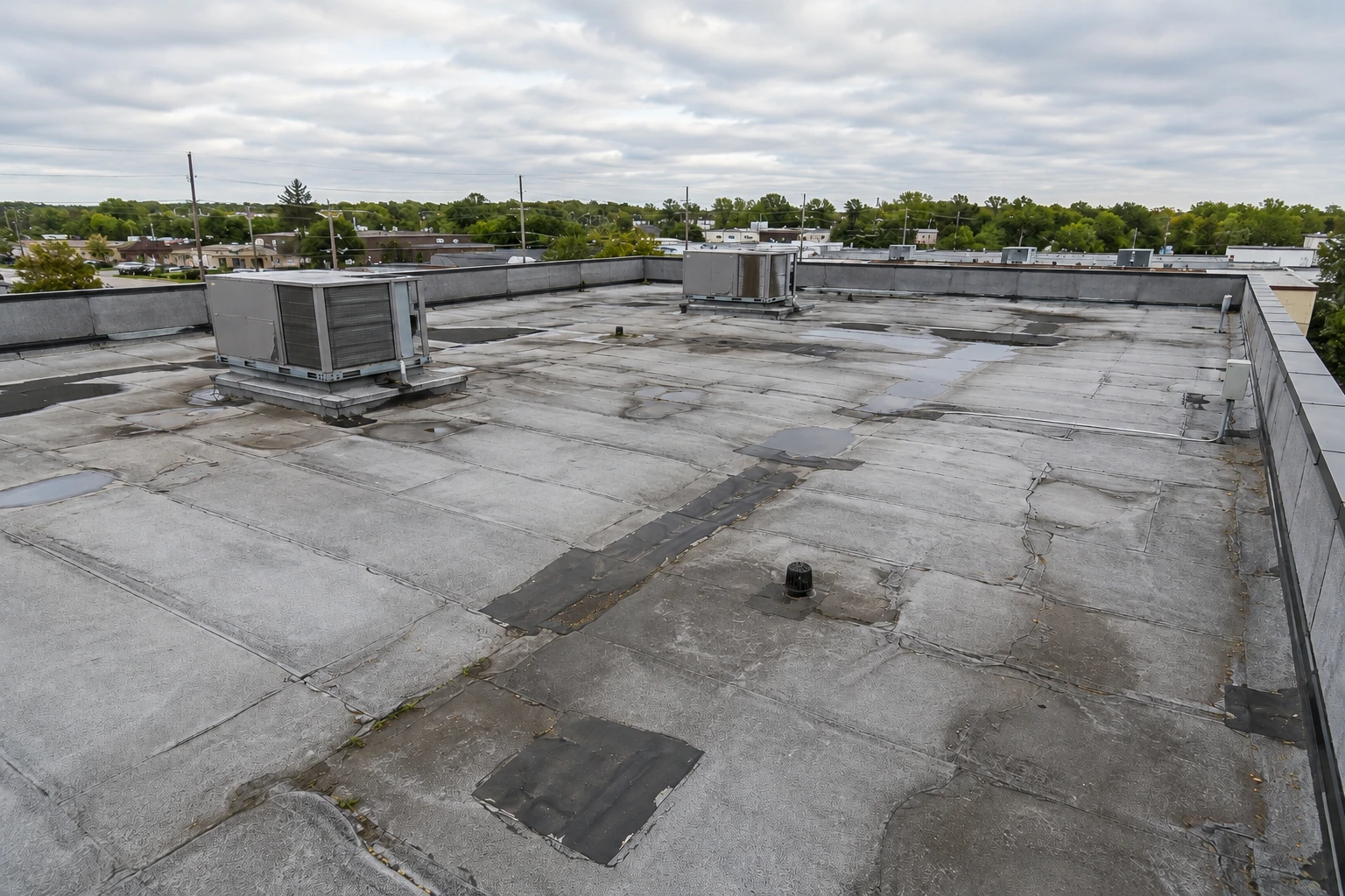 Before: weathered commercial flat roof with rooftop HVAC equipment